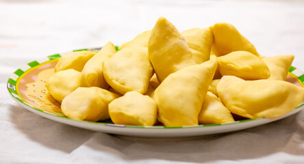 Verenik, pierogi, pierogui, perohê, Ukrainian food closeup on wooden table with wheat flour and rolling pin. 