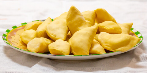 Verenik, pierogi, pierogui, perohê, Ukrainian food closeup on wooden table with wheat flour and rolling pin. 