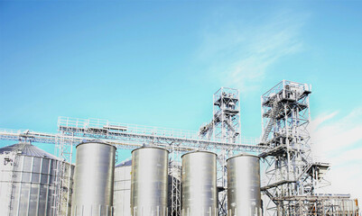 large metal containers of a modern elevator for drying and storing grain crops. high-capacity...