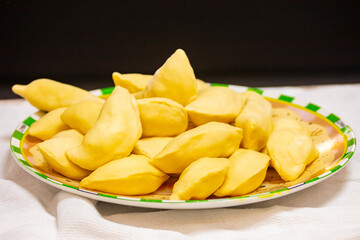 Verenik, pierogi, pierogui, perohê, Ukrainian food closeup on wooden table with wheat flour and rolling pin. 
