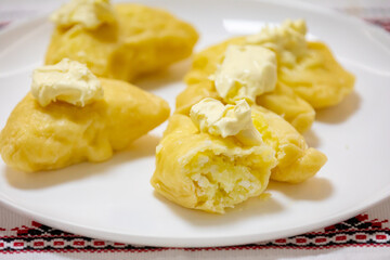 Verenik, pierogi, pierogui, perohê, Ukrainian food closeup on wooden table with wheat flour and rolling pin. 