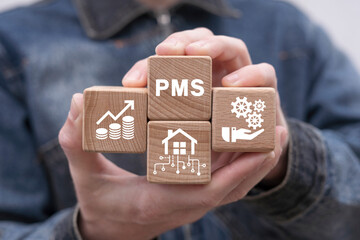 Man holding wooden blocks with icon sees abbreviation: PMS. Property Management System ( PMS )...