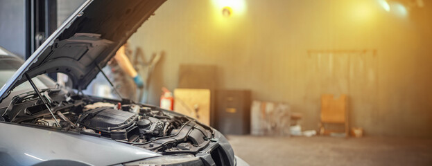 car repair concept in a car service center, open car hood in a garage. 
 - obrazy, fototapety, plakaty