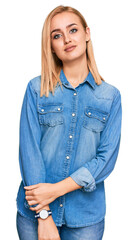 Beautiful caucasian woman wearing casual denim jacket relaxed with serious expression on face. simple and natural looking at the camera.