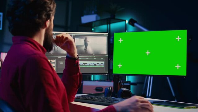 Video editor analyzing film montage on isolated screen display before editing color grading and lighting in creative office. Post production studio employee working with raw footage on chroma key PC