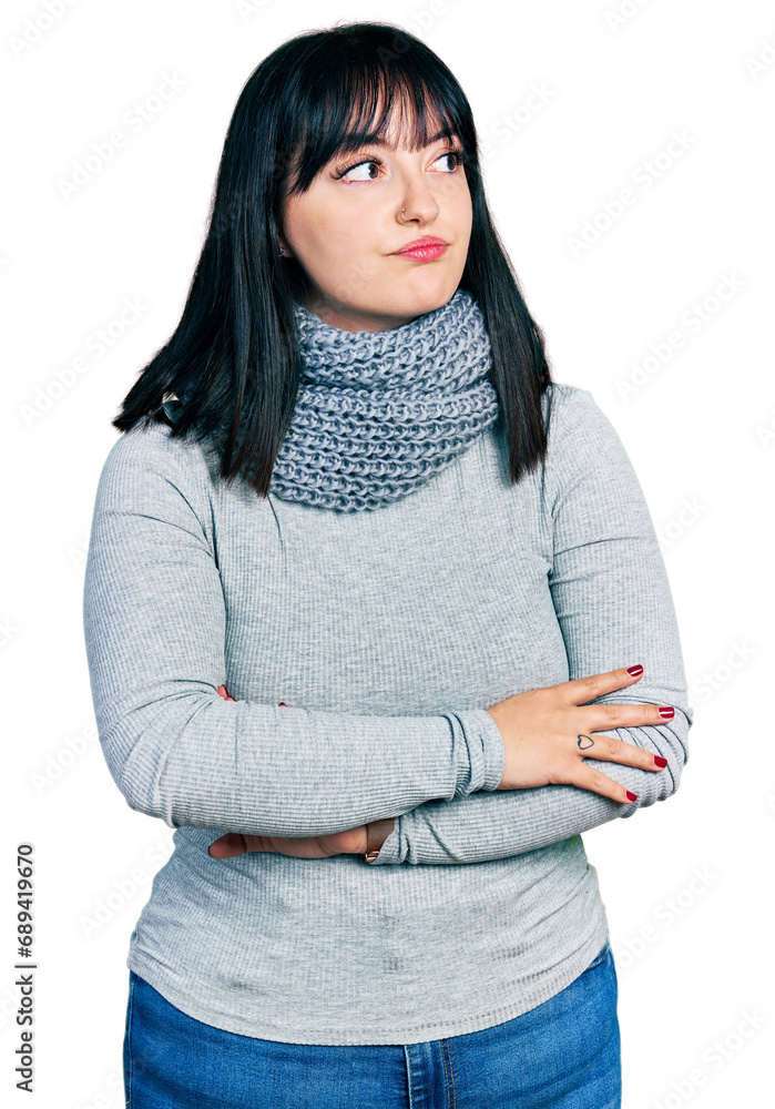 Sticker Young hispanic plus size woman wearing winter scarf looking to the side with arms crossed convinced and confident