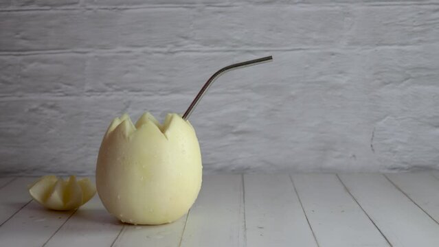 Melon with wine, melvin white, video, preparing, cocktail, place, straw. On white wooden table. Originally from Chile, summer. Typical Chilean food and drink