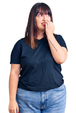 Young plus size woman wearing casual clothes looking stressed and nervous with hands on mouth biting nails. anxiety problem.