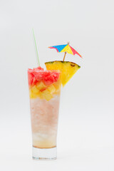 Cocktail drink with pineapple, straw and umbrella isolated on white background.
