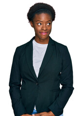 Young african american girl wearing business clothes smiling looking to the side and staring away...