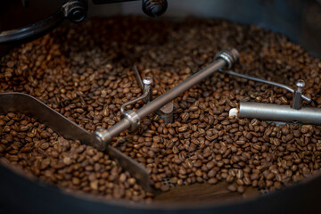Coffee beans during the roasting process, moving paddle of the screening hopper cooling the coffee beans after roasting. Drum type roaster
