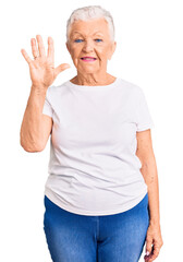 Senior beautiful woman with blue eyes and grey hair wearing casual white tshirt showing and pointing up with fingers number five while smiling confident and happy.