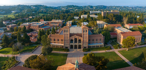 Aerial view of UCLA campus with Royce Hall center stage, Romanesque architecture, green spaces, and Westwood's urban backdrop in golden morning - afternoon light. - obrazy, fototapety, plakaty
