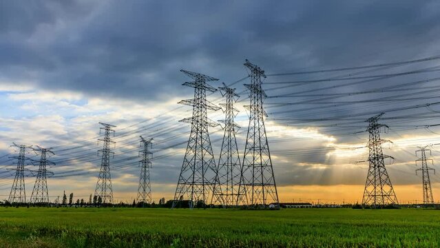 High voltage power tower and sky clouds at sunset. Transmission power line.