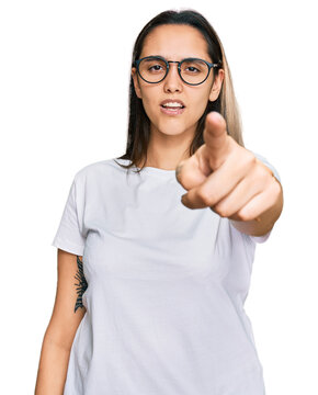 Young hispanic woman wearing casual white t shirt pointing displeased and frustrated to the camera, angry and furious with you