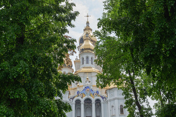 Church of the Holy Myrrh-Bearing Women seen between the green line trees of the park in kharkiv city