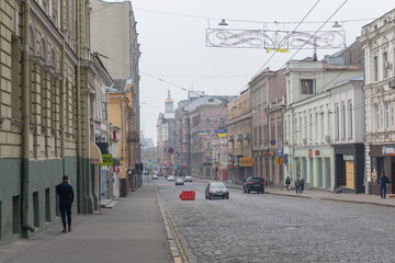 Fototapeta na wymiar cars and pedestrians passing on the historical street in kharkiv city
