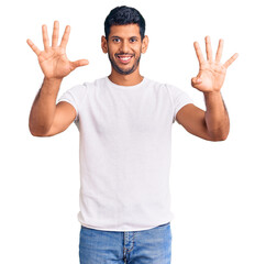 Naklejka premium Young latin man wearing casual clothes showing and pointing up with fingers number nine while smiling confident and happy.