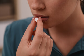 Woman taking antidepressant pill on blurred background, closeup - obrazy, fototapety, plakaty