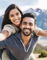Obraz premium cheerful young adult couple on vacation in mountains, woman leans on man's back while they open arms, vacation concept, happy valentines day