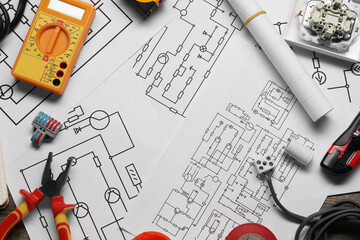 Wiring diagrams, digital multimeter and other electrician's equipment on table, flat lay