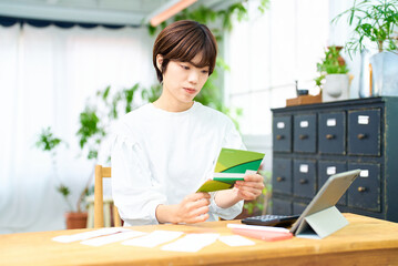 通帳を眺める若い女性