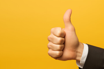 Businessman hand thumb up from yellow punched paper for client the best satisfaction evaluation survey after use product and service concept, yellow background