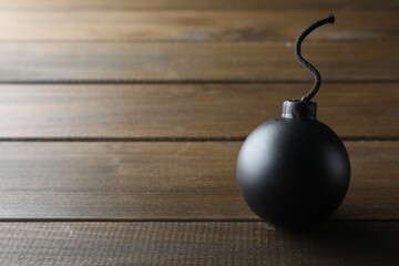 Old fashioned fuse bomb on wooden table. Space for text