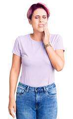 Young beautiful woman with pink hair wearing casual clothes touching mouth with hand with painful expression because of toothache or dental illness on teeth. dentist