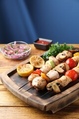 Delicious shish kebabs with grilled vegetables served on wooden table