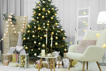 Beautiful Christmas tree, gift boxes and armchair in festive decorated room. Interior design
