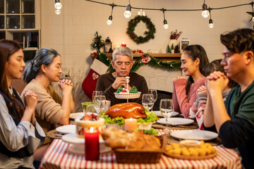 Asian lovely family say a prayer before celebrate Christmas dinner party. 