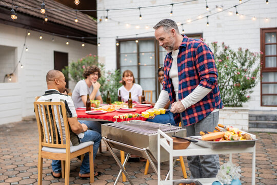 Multi-ethnic family having fun, enjoy party outdoors in the garden. 