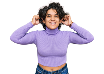 Young hispanic woman with curly hair wearing casual clothes smiling pulling ears with fingers, funny gesture. audition problem