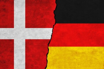 Germany and Denmark painted flags on a wall with a crack. Denmark and Germany relations. Germany and Denmark flags together