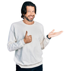 Middle age caucasian man wearing casual clothes showing palm hand and doing ok gesture with thumbs up, smiling happy and cheerful