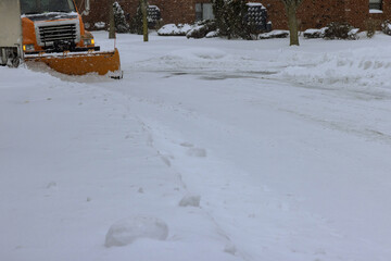 After heavy snowstorm, snowstorm snowplow trucks remove snow from road at residential area