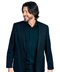 Middle age caucasian man wearing business clothes looking to side, relax profile pose with natural face and confident smile.