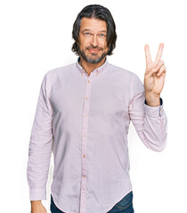 Middle age handsome man wearing business shirt showing and pointing up with fingers number two while smiling confident and happy.