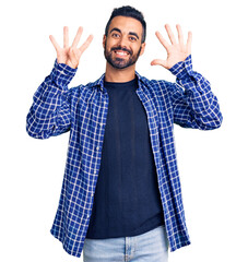 Young hispanic man wearing casual clothes showing and pointing up with fingers number nine while...