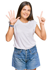 Young caucasian woman wearing casual white tshirt showing and pointing up with fingers number seven while smiling confident and happy.