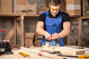 Worker grinds the wood of angular grinding machine