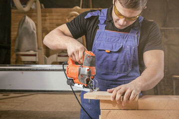 A carpenter using a jigsaw to cut wood cuts bars. Home repair concepts, close up.