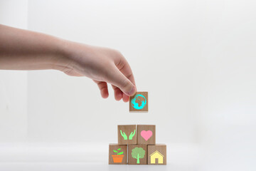 world saving by corporate hand,love heart,plant,tree,forest and ecosystem icon on wood block in minimal earth day concept
