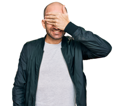 Young hispanic man wearing casual clothes smiling and laughing with hand on face covering eyes for surprise. blind concept.