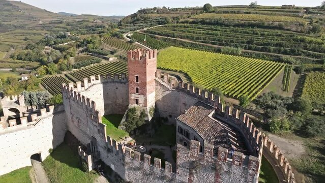Medieval Scaliger Castle With Vineyards And Rural Landscape In The Background In Soave, Italy. - aerial shot