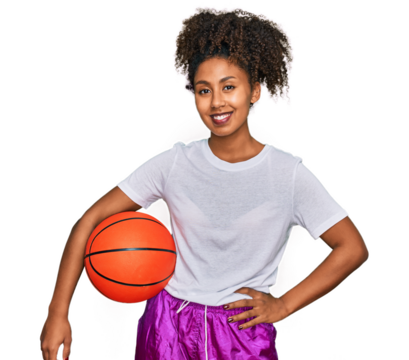 Young african american girl playing baseball holding bat and ball looking positive and happy standing and smiling with a confident smile showing teeth - Powered by Adobe