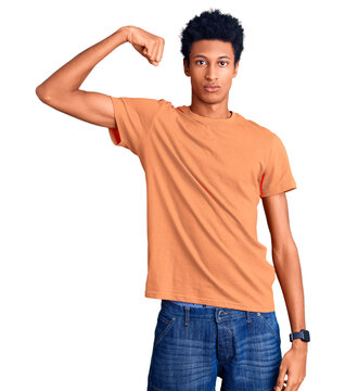 Young african american man wearing casual clothes strong person showing arm muscle, confident and proud of power