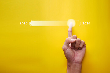 Finger touching status bar changing from 2023 to 2024 for countdown Merry Christmas and New Year with technology concept, Starting a new business and new life. - obrazy, fototapety, plakaty