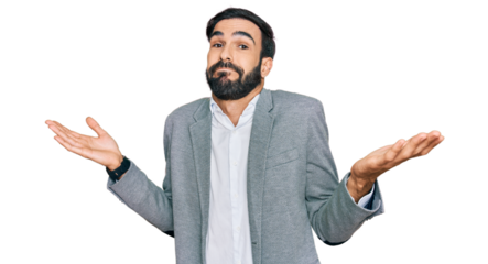 Young hispanic man wearing business clothes clueless and confused expression with arms and hands raised. doubt concept.